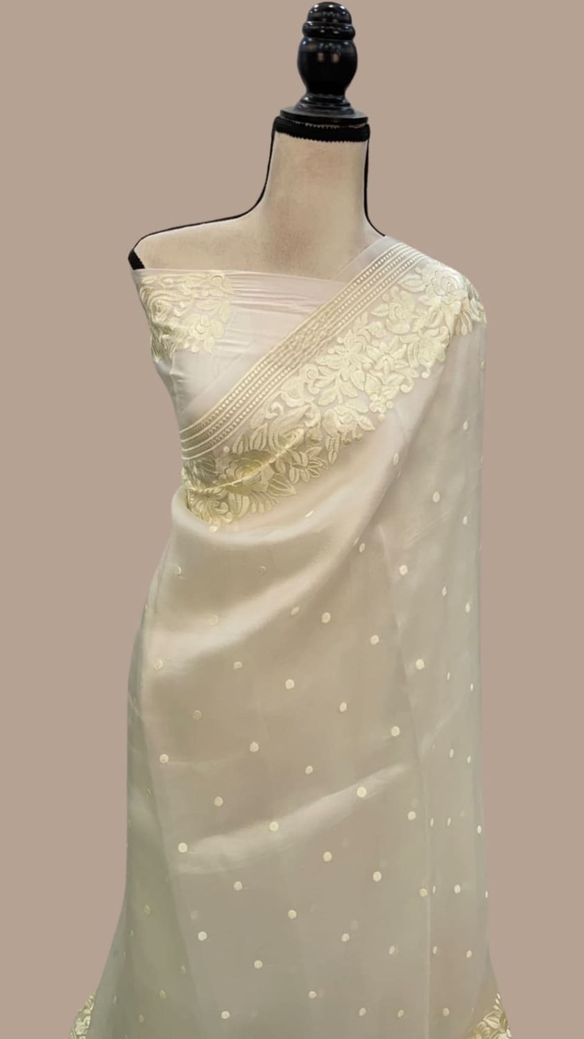 Off-white organza saree drape with gold floral zari border and tiny dot embellishments