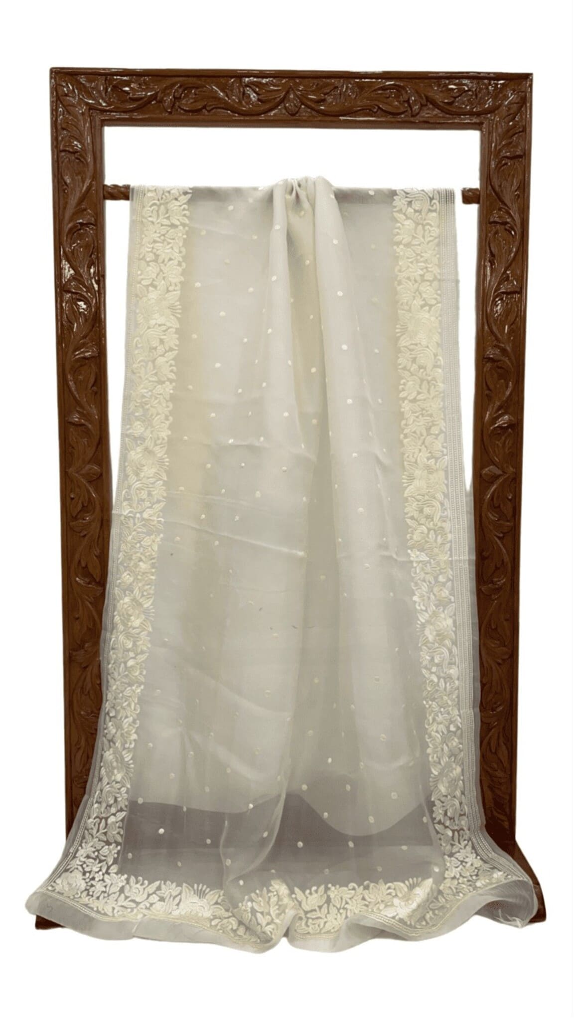 Off-white organza saree laid out flat with lace border and small dotted work
