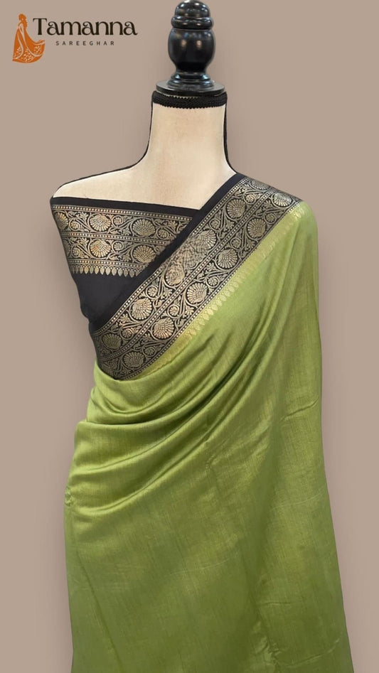 Olive green silk saree with black and gold pallu border, draped on mannequin