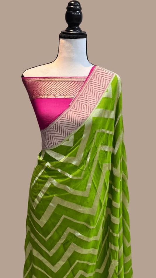 Olive green saree draped with green chevron design and pink/gold zari border