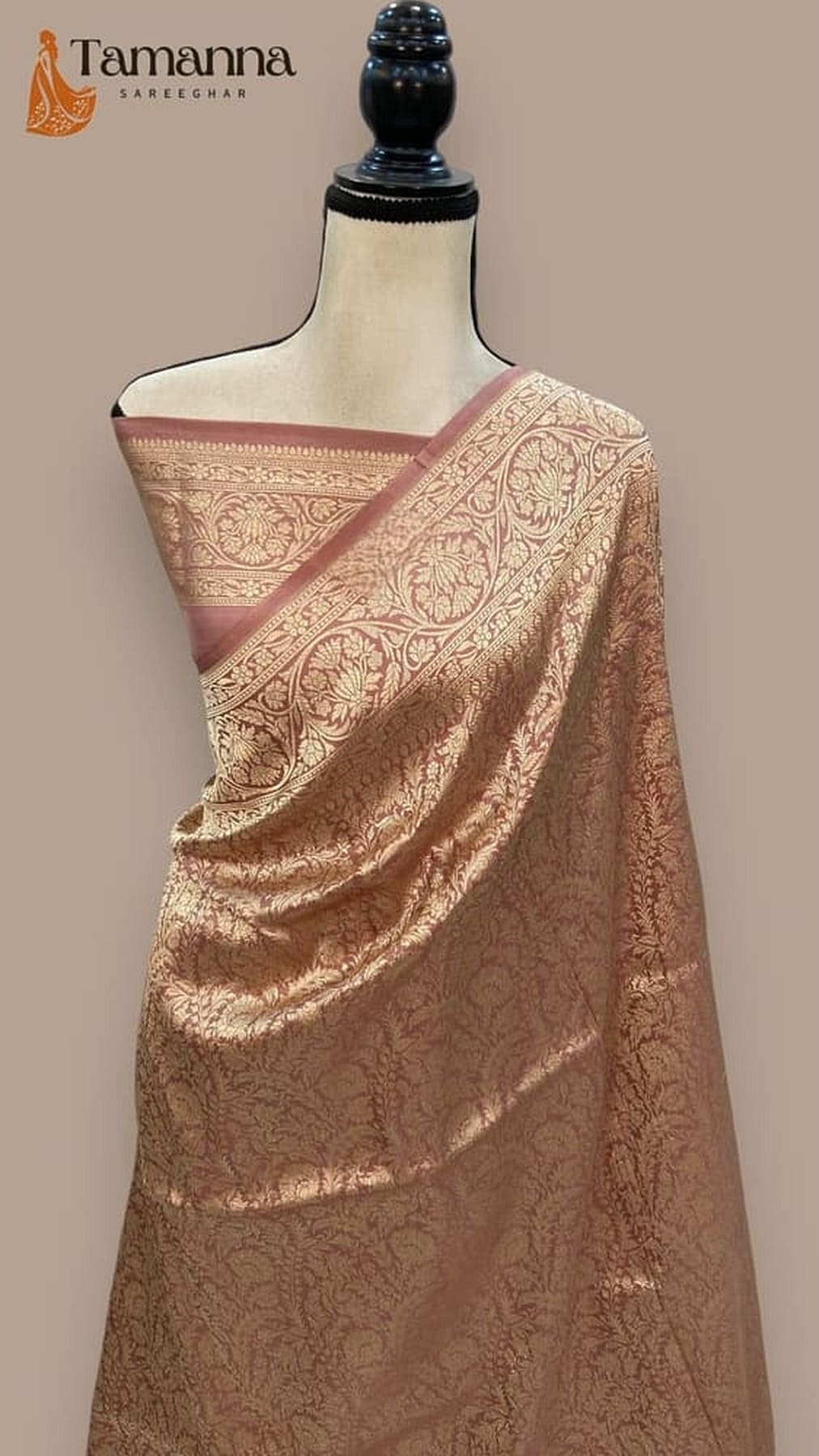 Rose-gold silk saree with pink border and intricate brocade motifs, draped on mannequin