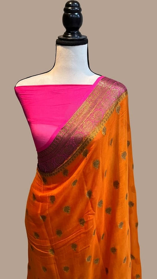 Orange saree with magenta back pleat and gold zari border, mannequin display