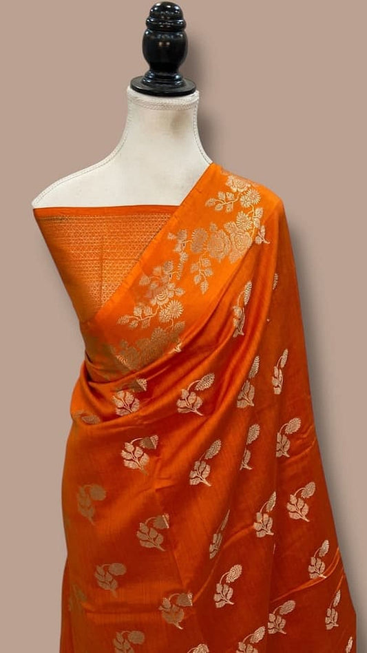 Orange silk Banarasi saree with gold pallu border and floral zari motifs, draped on mannequin