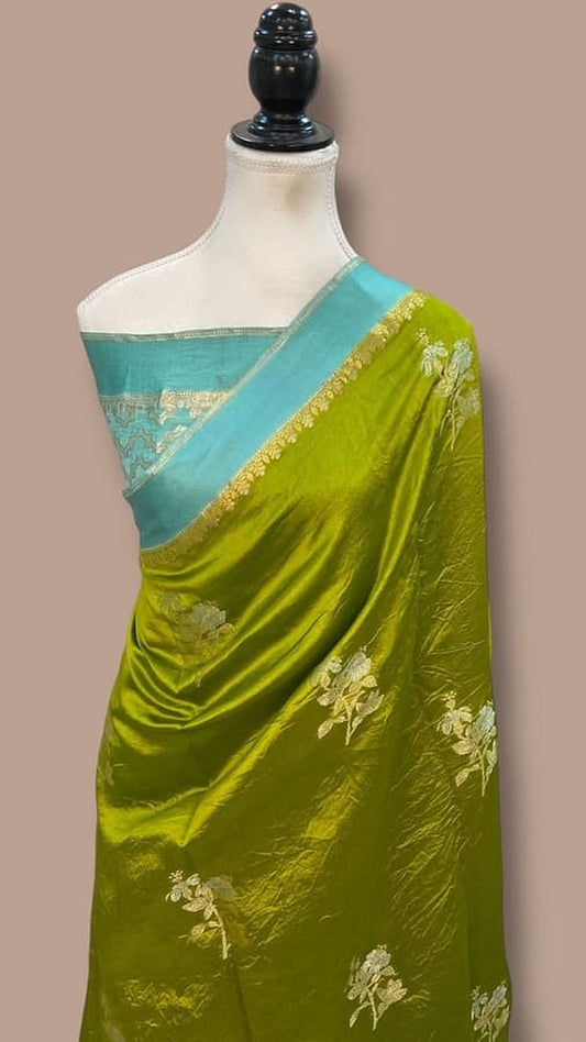 Green silk saree with teal border and gold motifs on pallu, worn on mannequin
