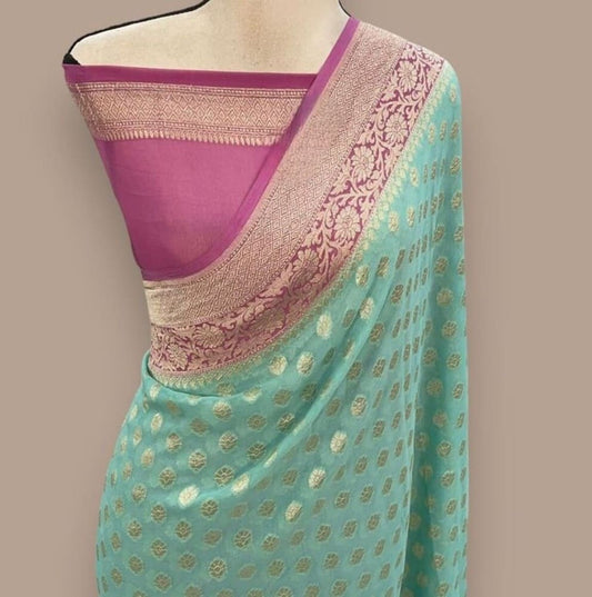Turquoise georgette saree with gold motifs and mauve-purple border, peach-pink pallu