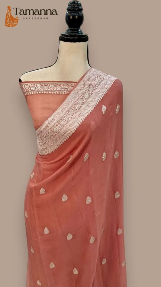 Draped peach saree on mannequin with woven pallu edge and scattered motif dots