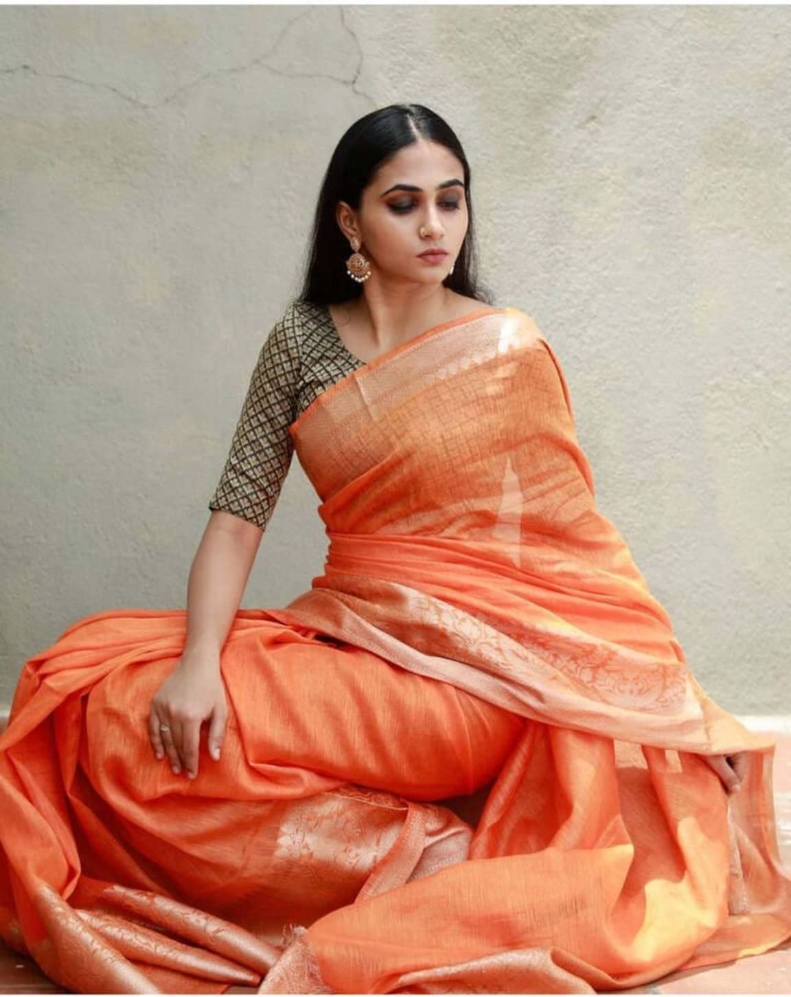 Peach-orange linen Banarasi saree with cream zari trim and pleated skirt
