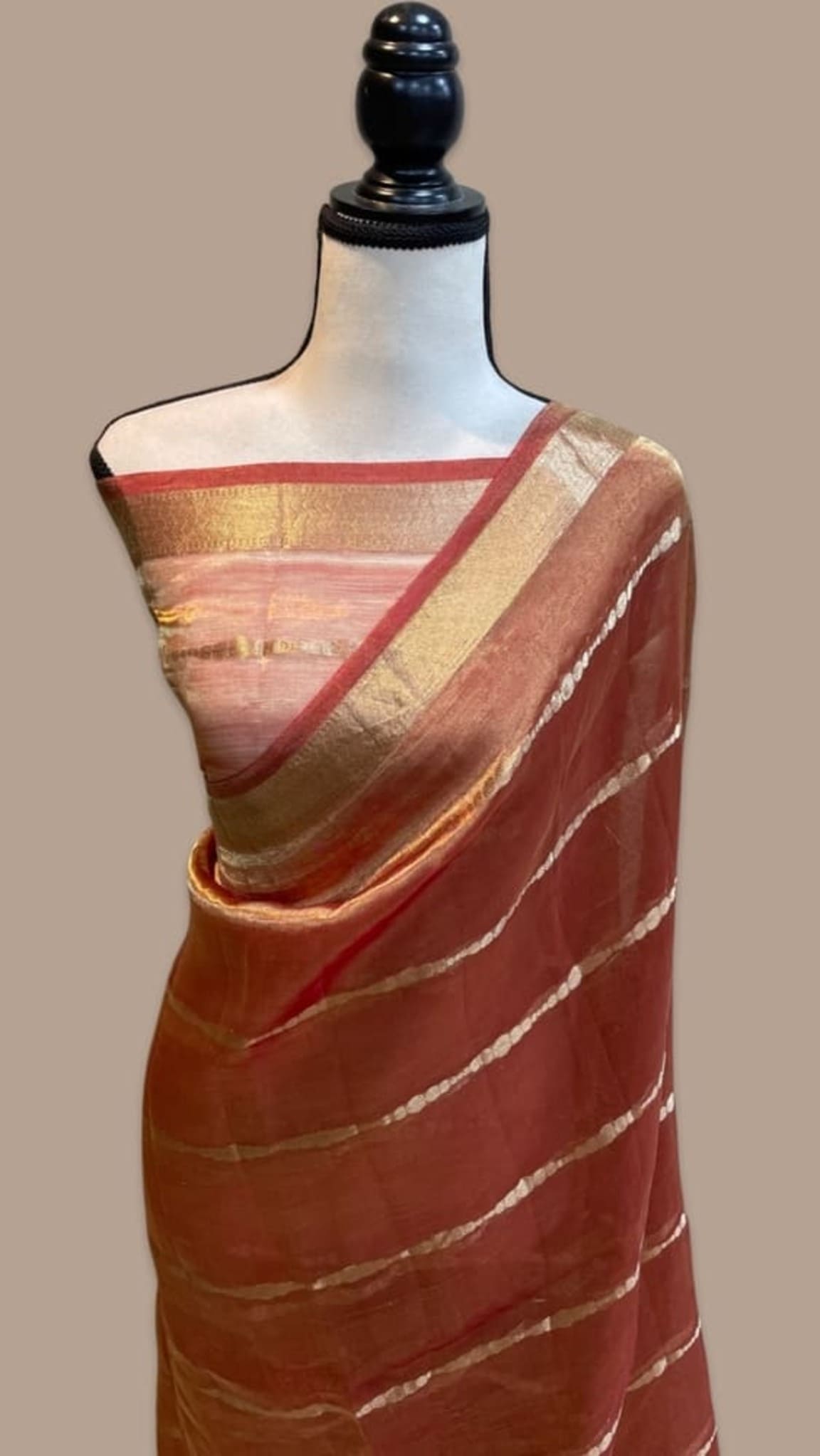 Peach Banarasi tissue saree on mannequin, maroon border with gold stripes