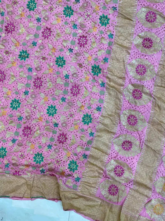 Close-up of pink saree with teal floral motifs, repeating small prints, and border detailing