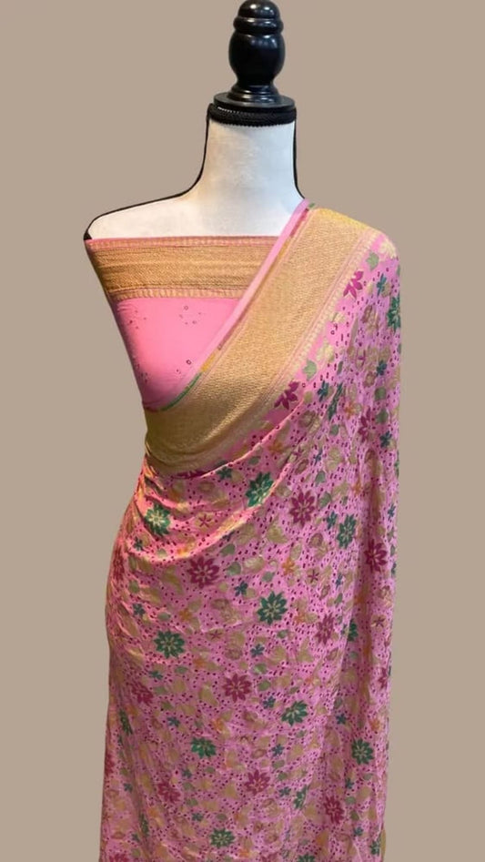 Draped pink saree with gold pallu edge and detailed floral pattern on a mannequin