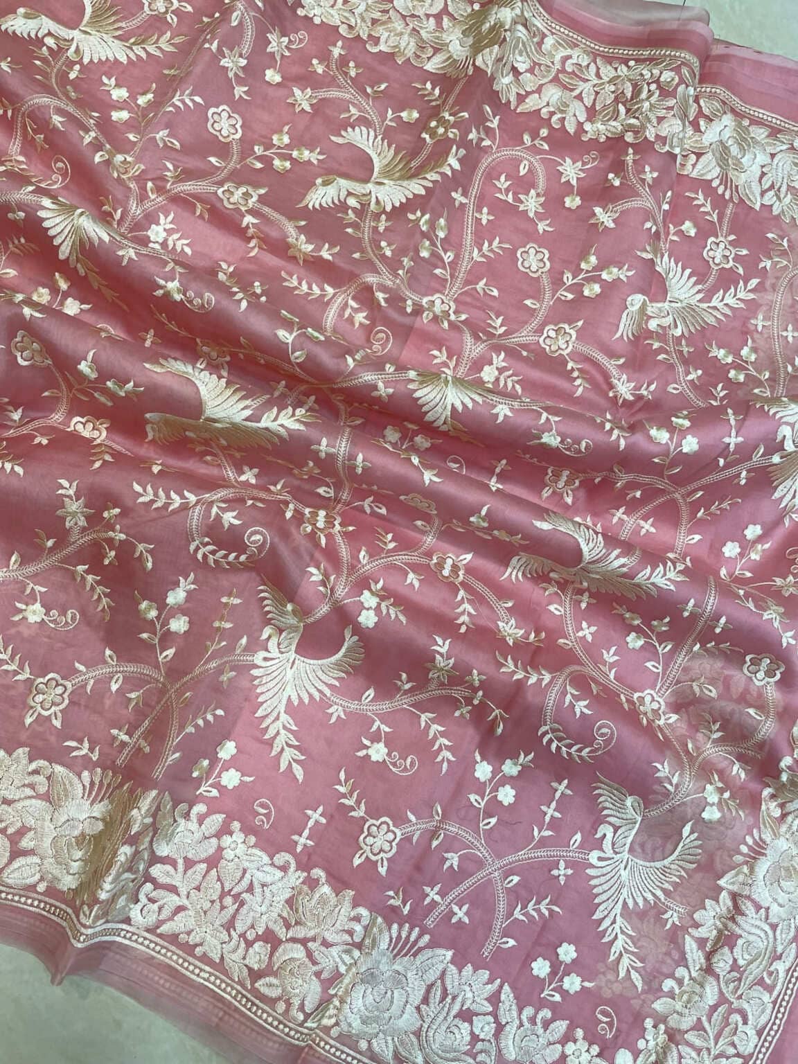 Pink organza close-up with ornate silver border and embroidered floral vine pattern