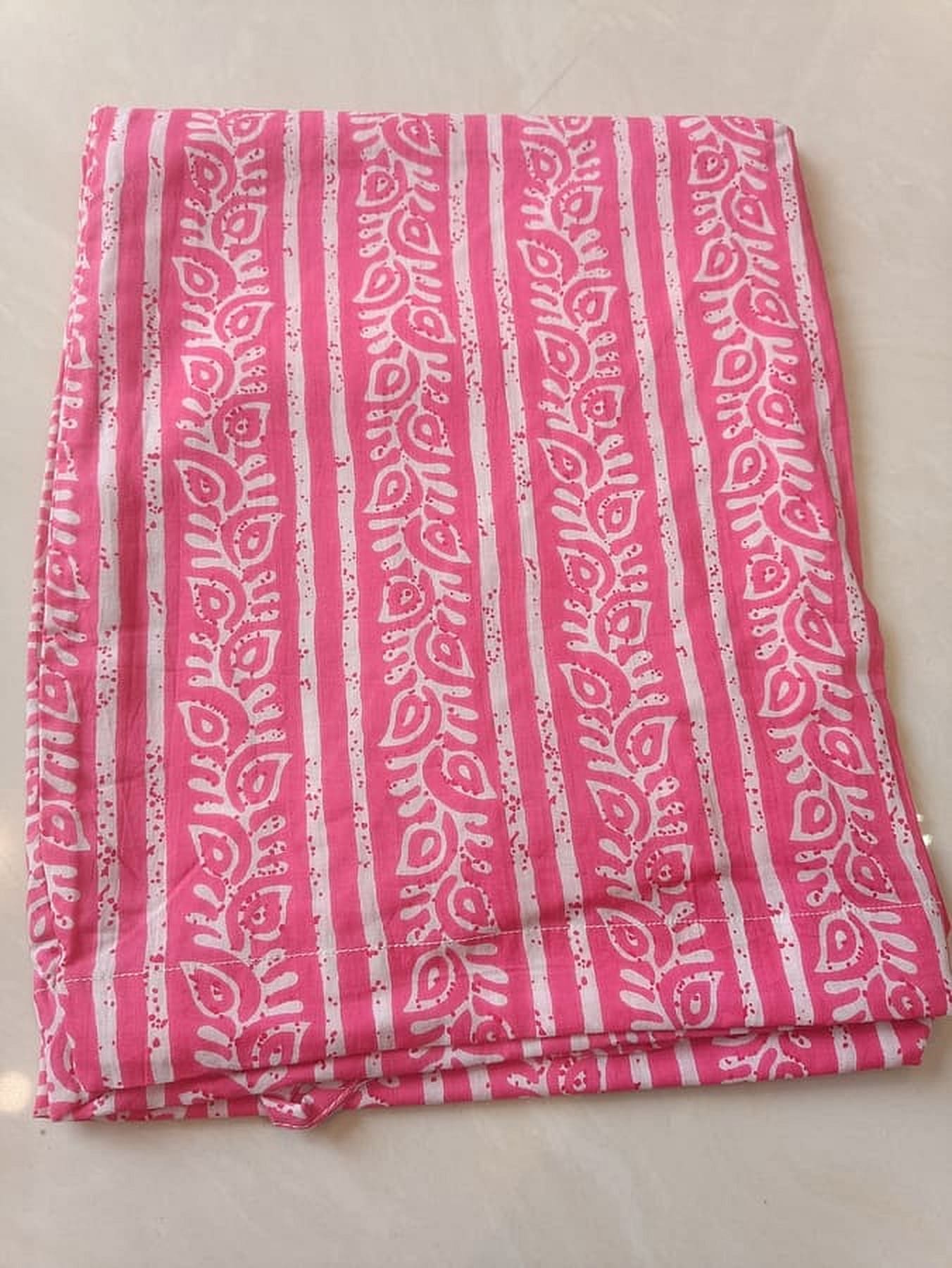 Pink printed cotton bottom fabric with vertical stripes and ornamental band at hem