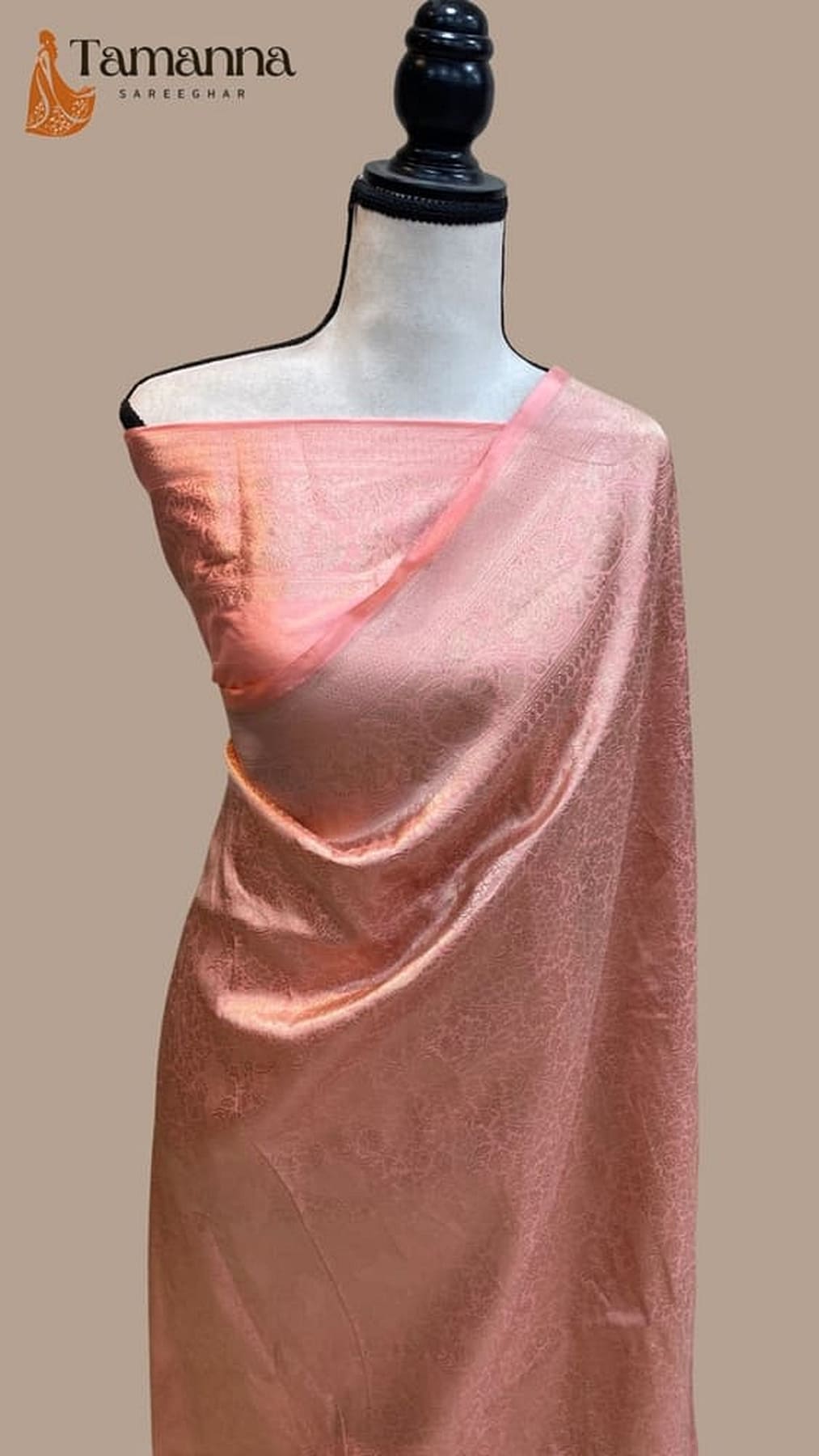 Pink silk saree on mannequin with patterned pallu fold and wide shimmering border