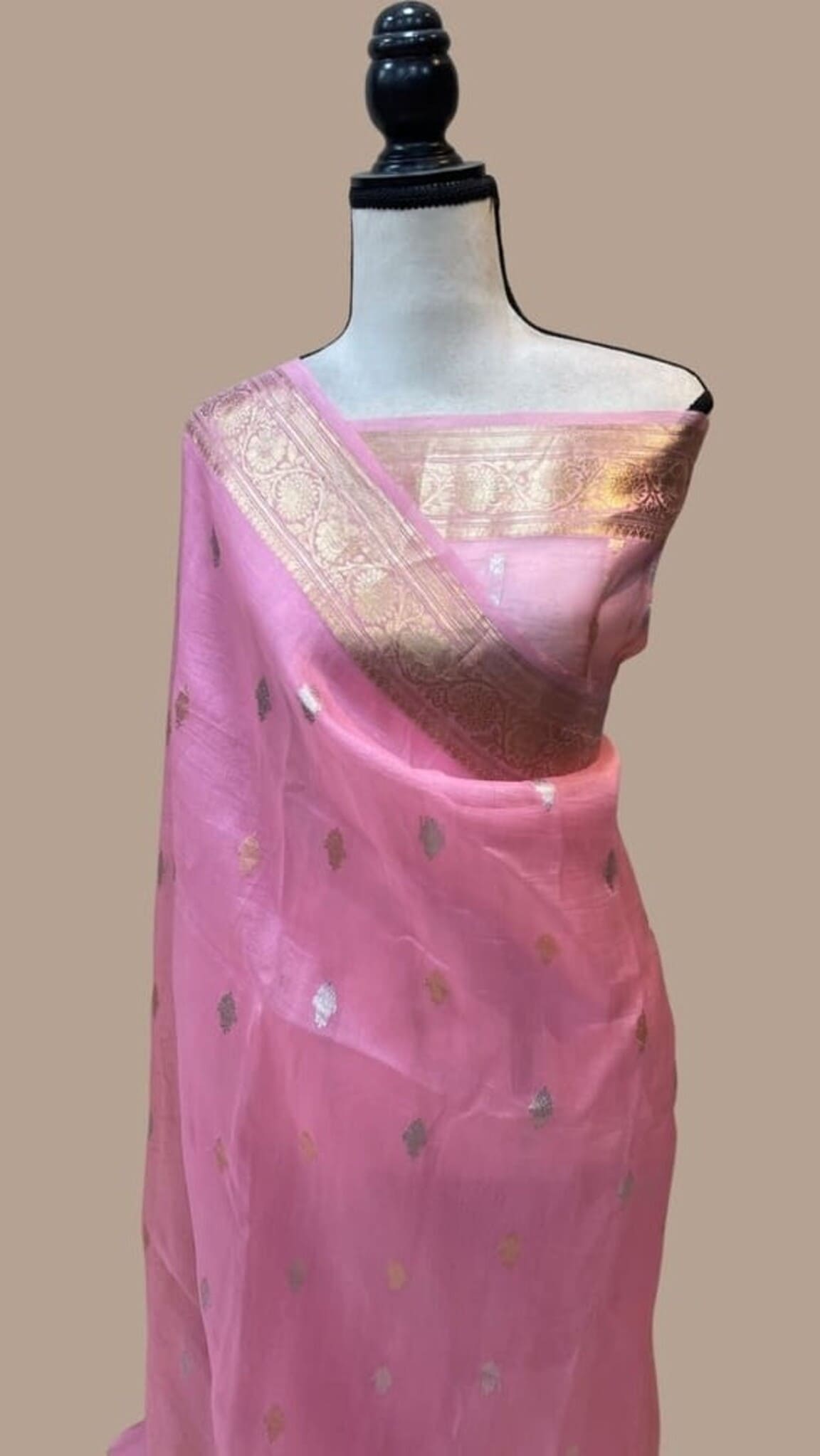 Pink Banarasi saree on mannequin with gold zari border and scattered motif pattern