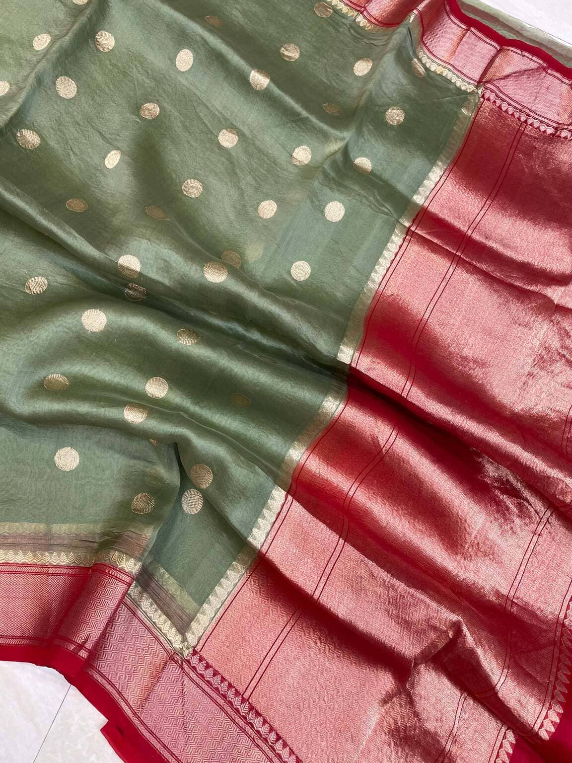 Green saree with gold polka dots and red section with woven border detail