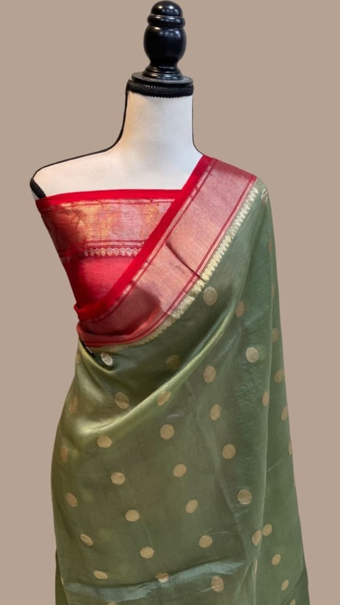 Olive green saree with gold polka dots and red Banarasi border on mannequin