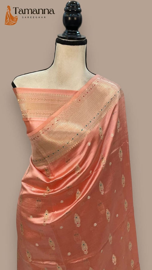 Peach silk saree draped on mannequin, gold border and scattered zari motifs