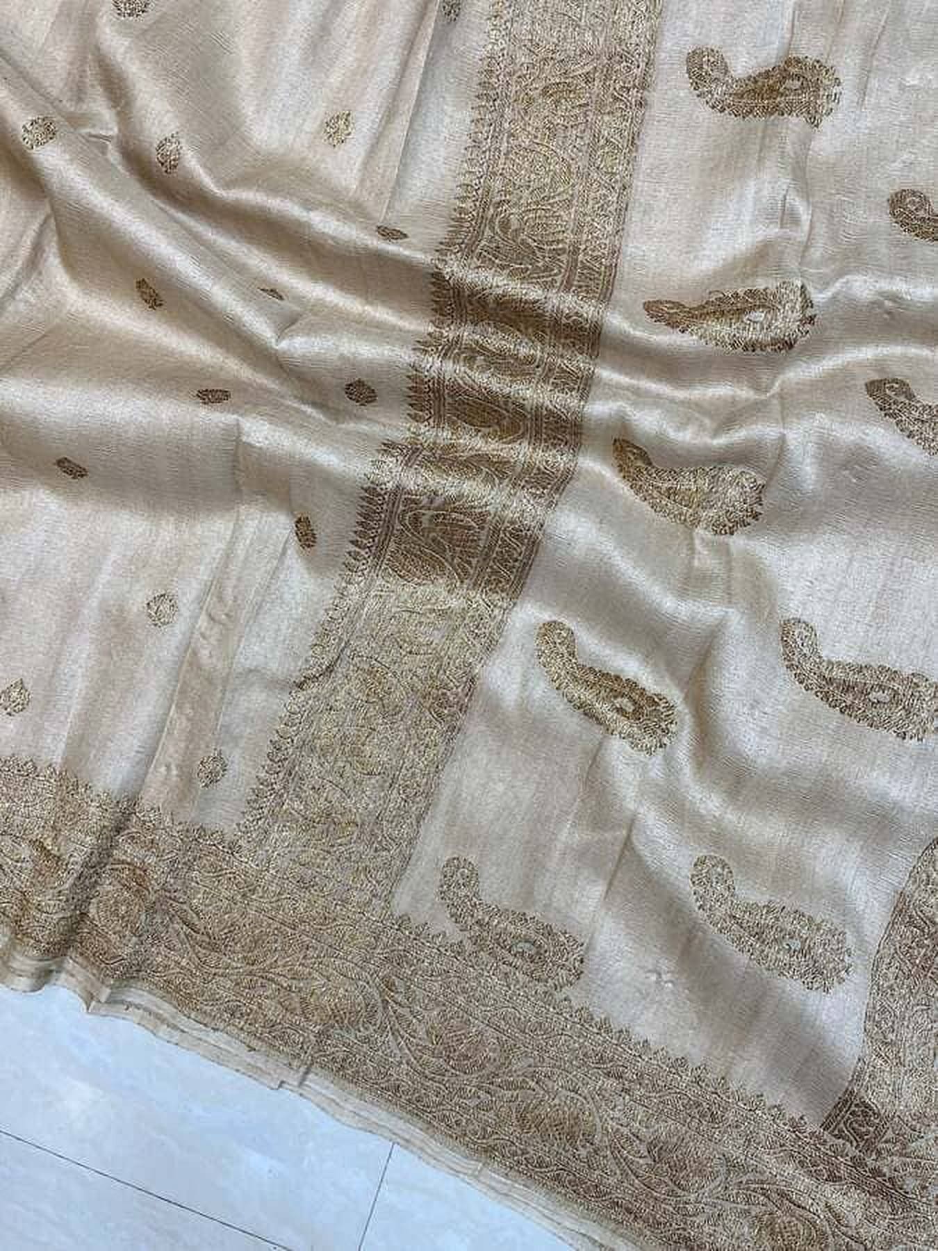 Off-white saree fabric with gold zari motifs and woven border edge