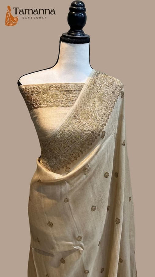 Cream Banarasi saree with wide gold zari pallu border and small motifs