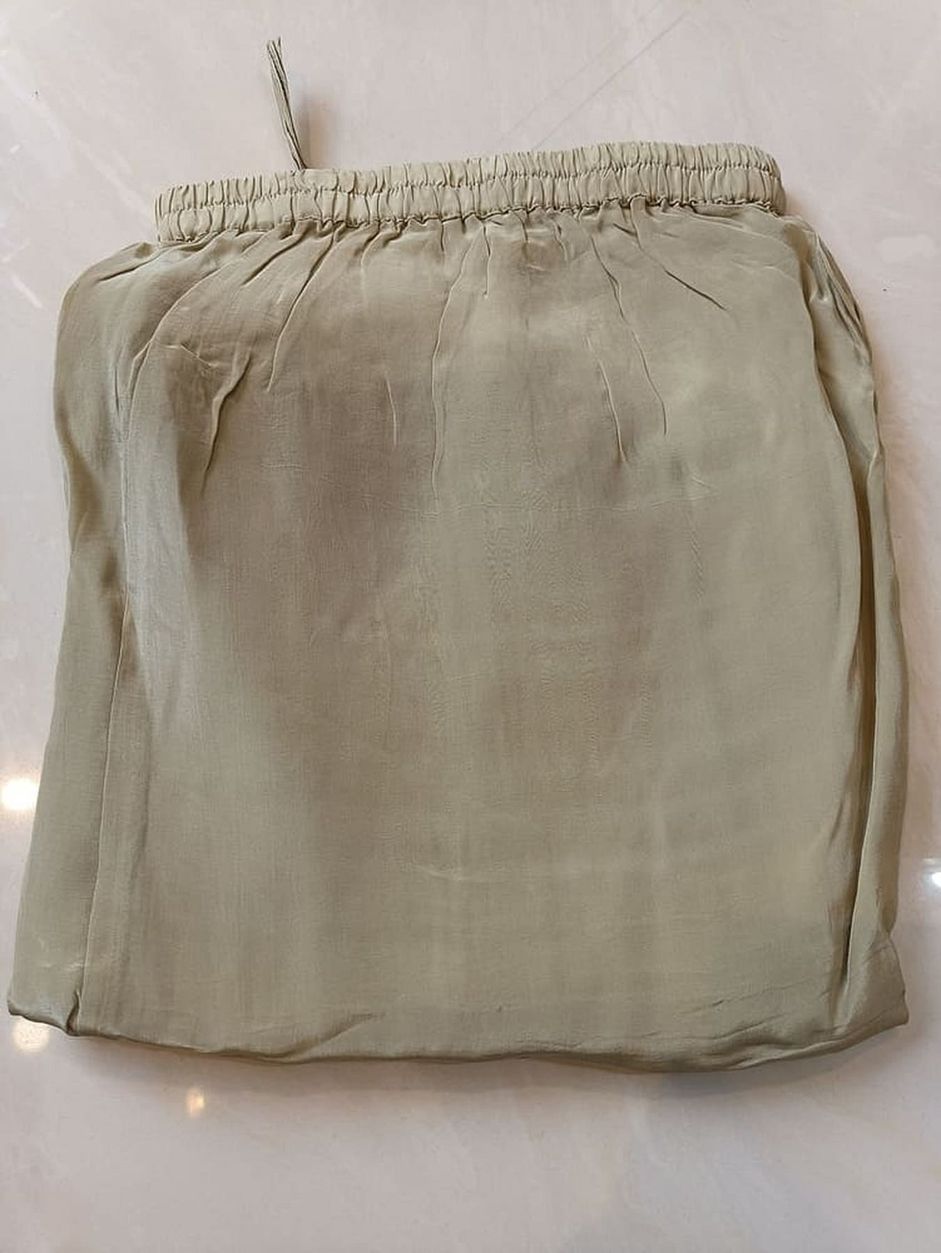 Beige kurta back view with elastic gathered waist and smooth plain fabric