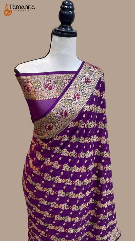 Purple saree with gold zari pallu and patterned border draped on mannequin