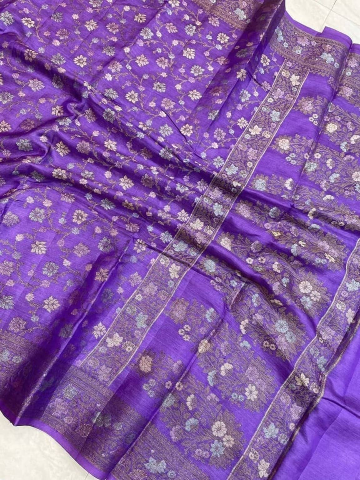 Purple crepe saree close-up with gold floral motifs and woven metallic border
