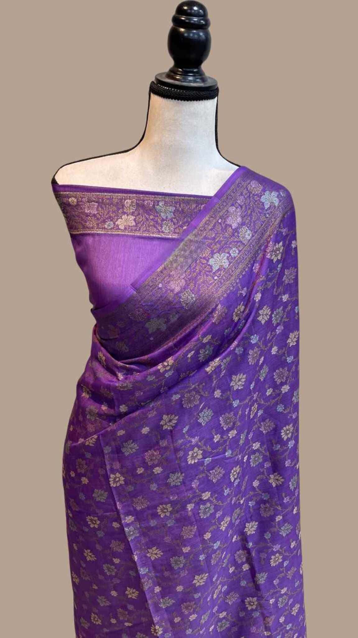 Purple crepe saree with gold floral pattern and pallu border, draped on mannequin