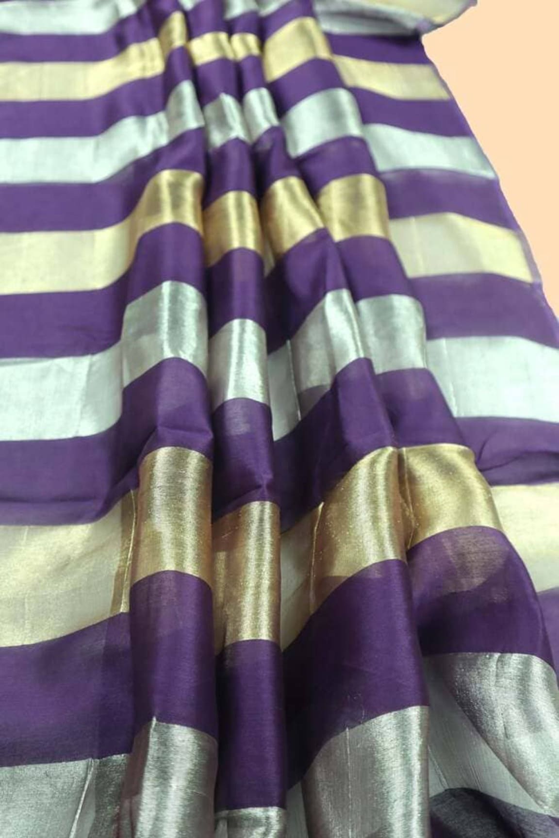 Purple tissue saree close-up of metallic silver, gold, and light stripe bands