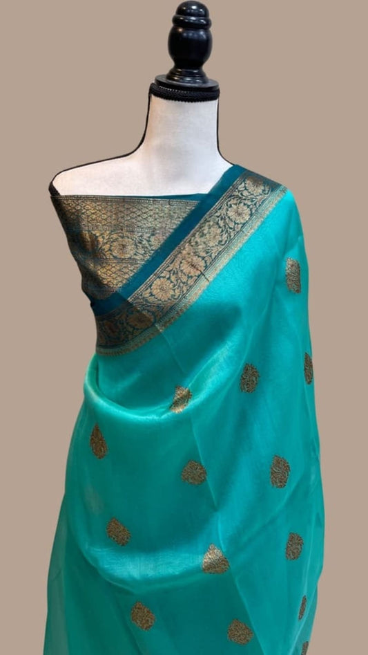 Teal silk saree with gold leaf motifs and dark green brocade border