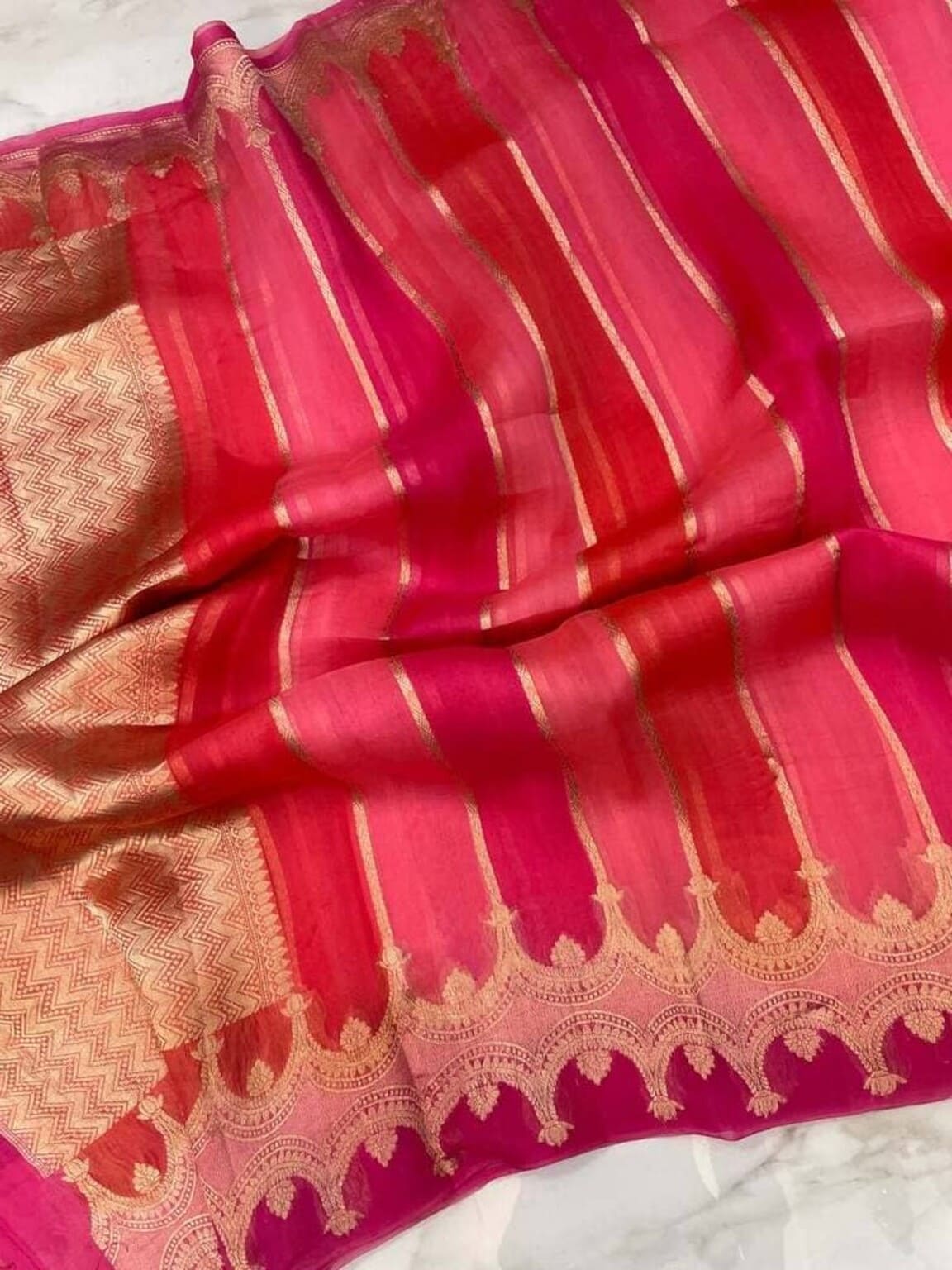 Pink Banarasi saree fabric close-up, gold striped weave and sheen