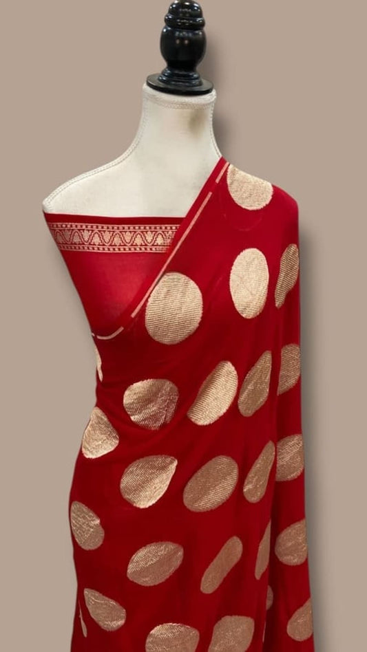 Red saree with gold oval motifs, draped on cream base and border pallu