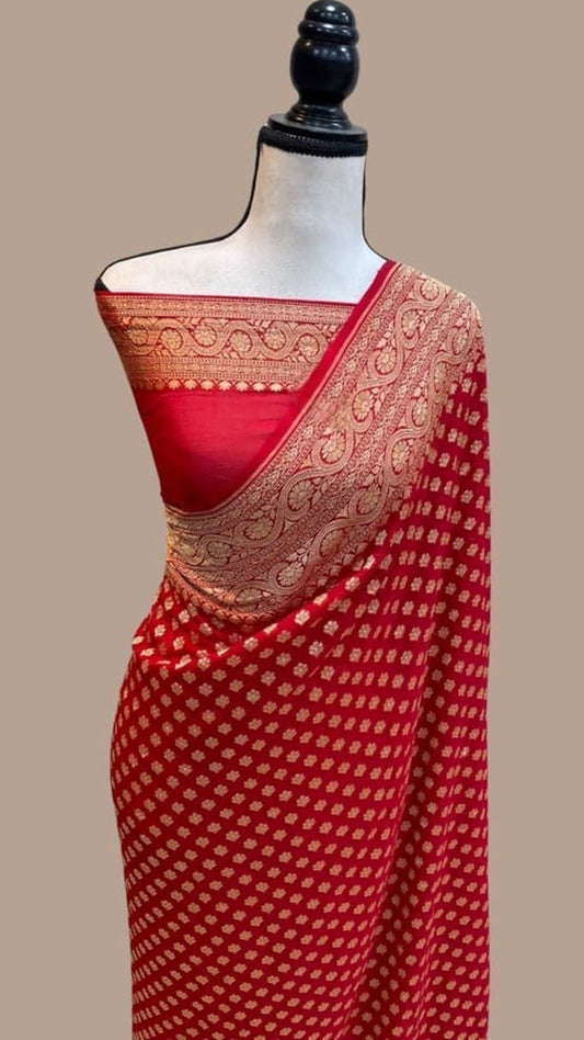 Red georgette saree with gold zari border and patterned pallu draped on mannequin