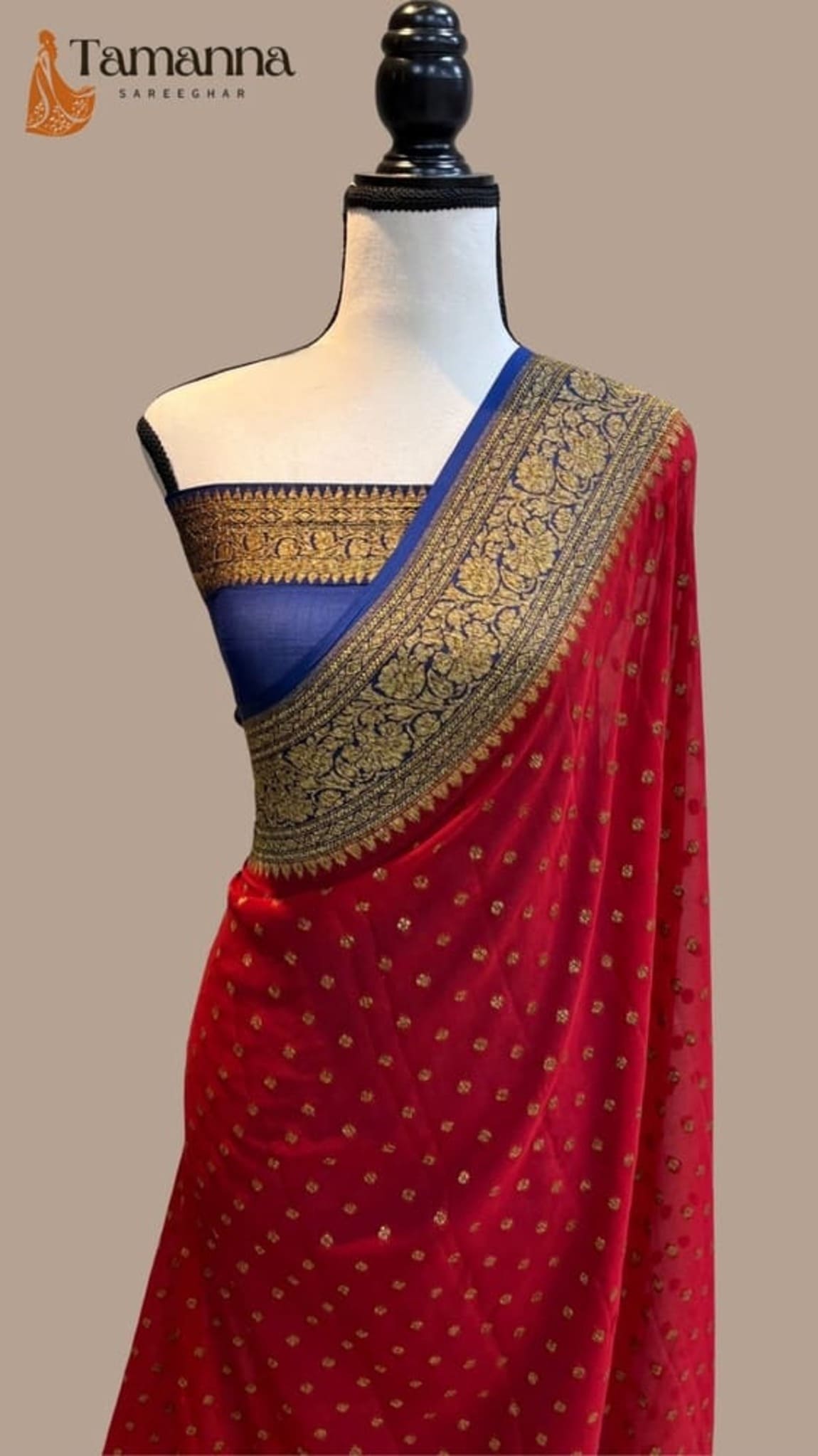 Red saree draped with blue blouse band and antique-gold zari pallu on mannequin