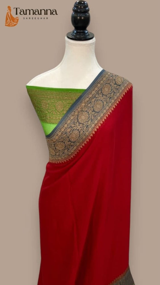 Red saree drape on mannequin with green pallu and ornate blue-gold border