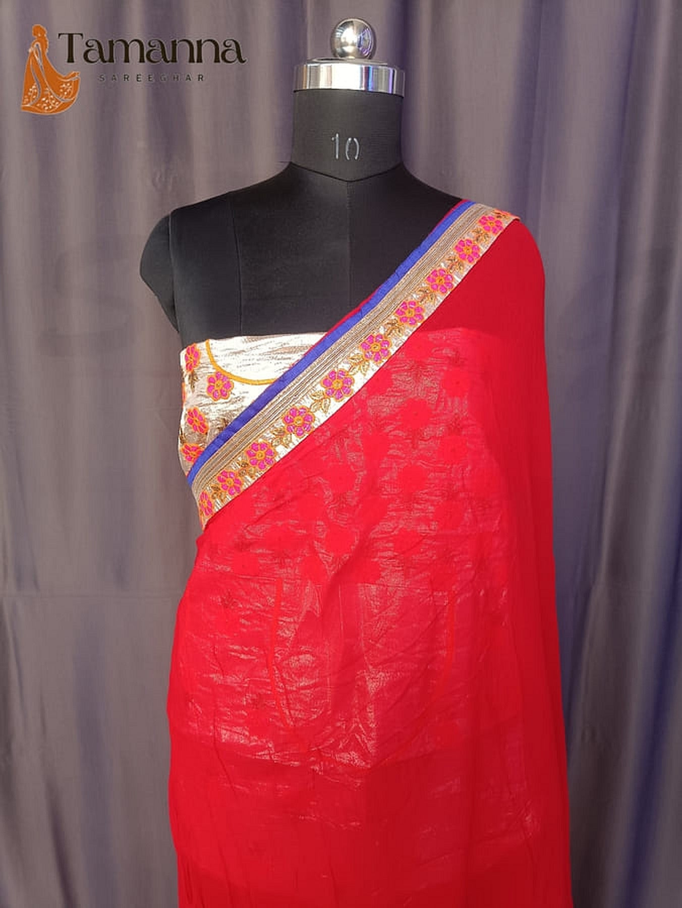 Red georgette saree end with blue-and-gold border and floral trim