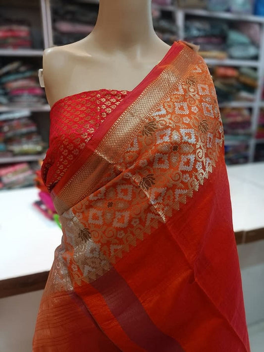 Red-orange silk saree with gold trim and geometric motif pallu, draped on mannequin