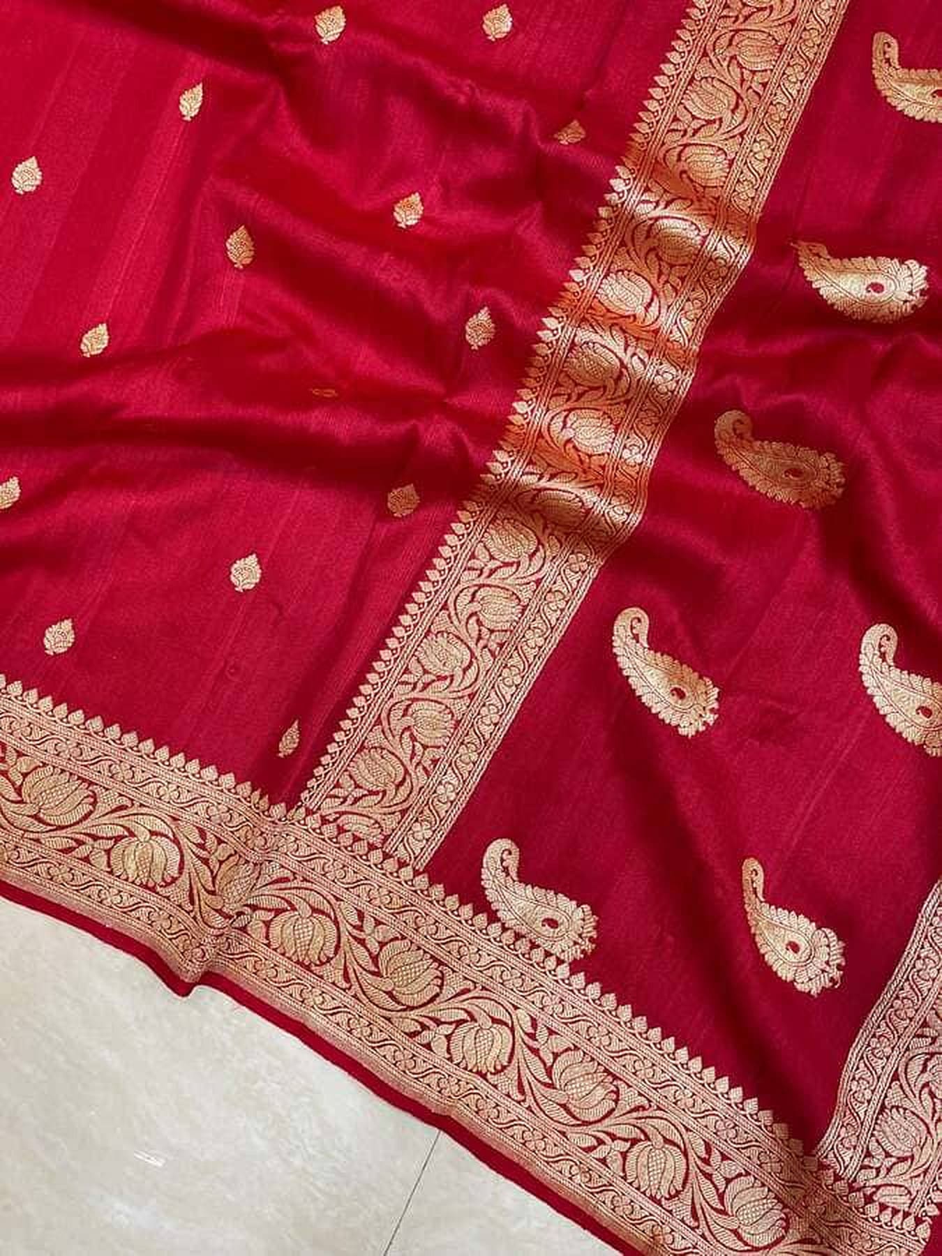 Red saree close-up with gold zari edging and paisley-like motif pattern