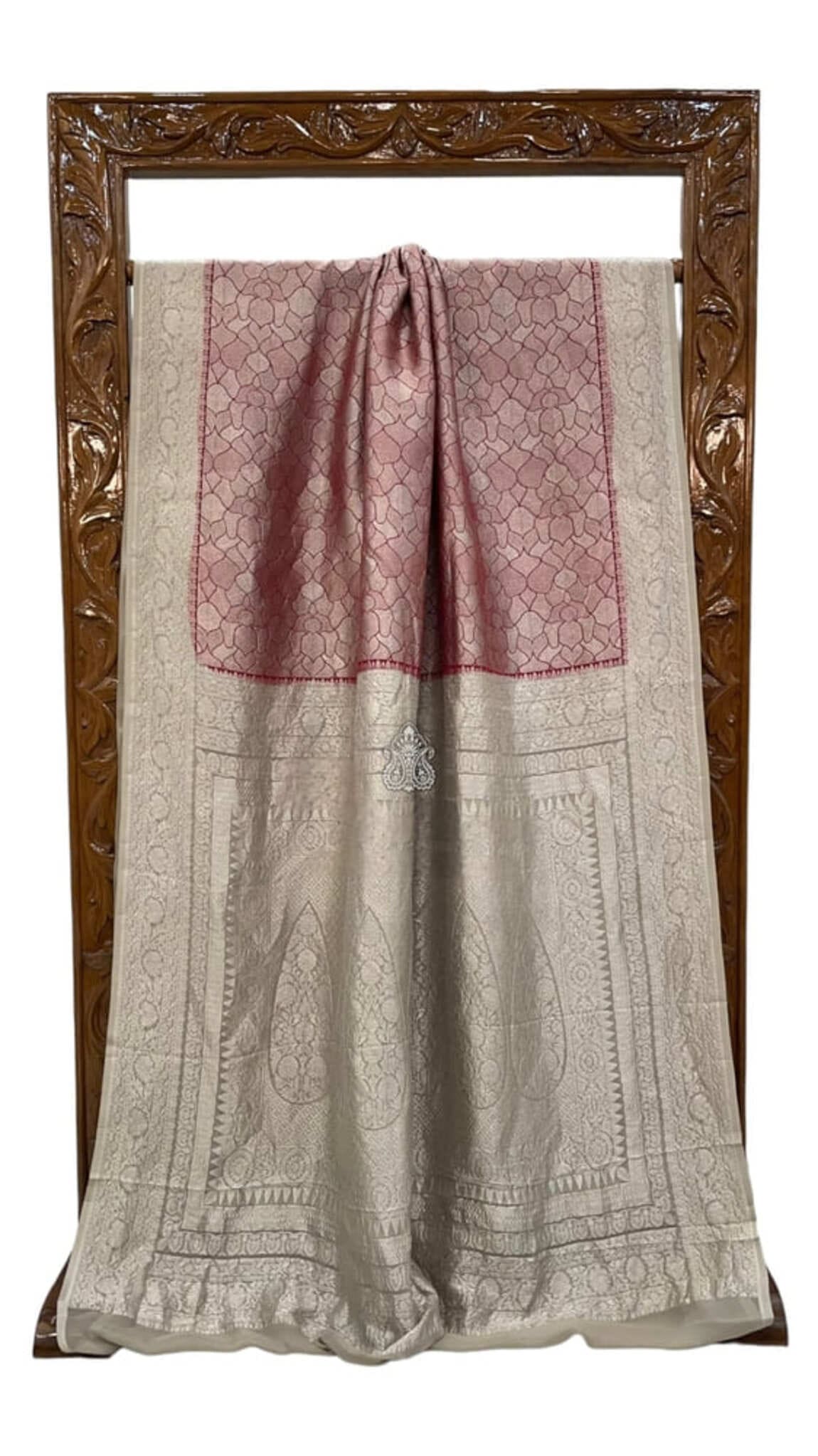 Red Banarasi saree draped flat, cream border with woven motifs and contrast piping