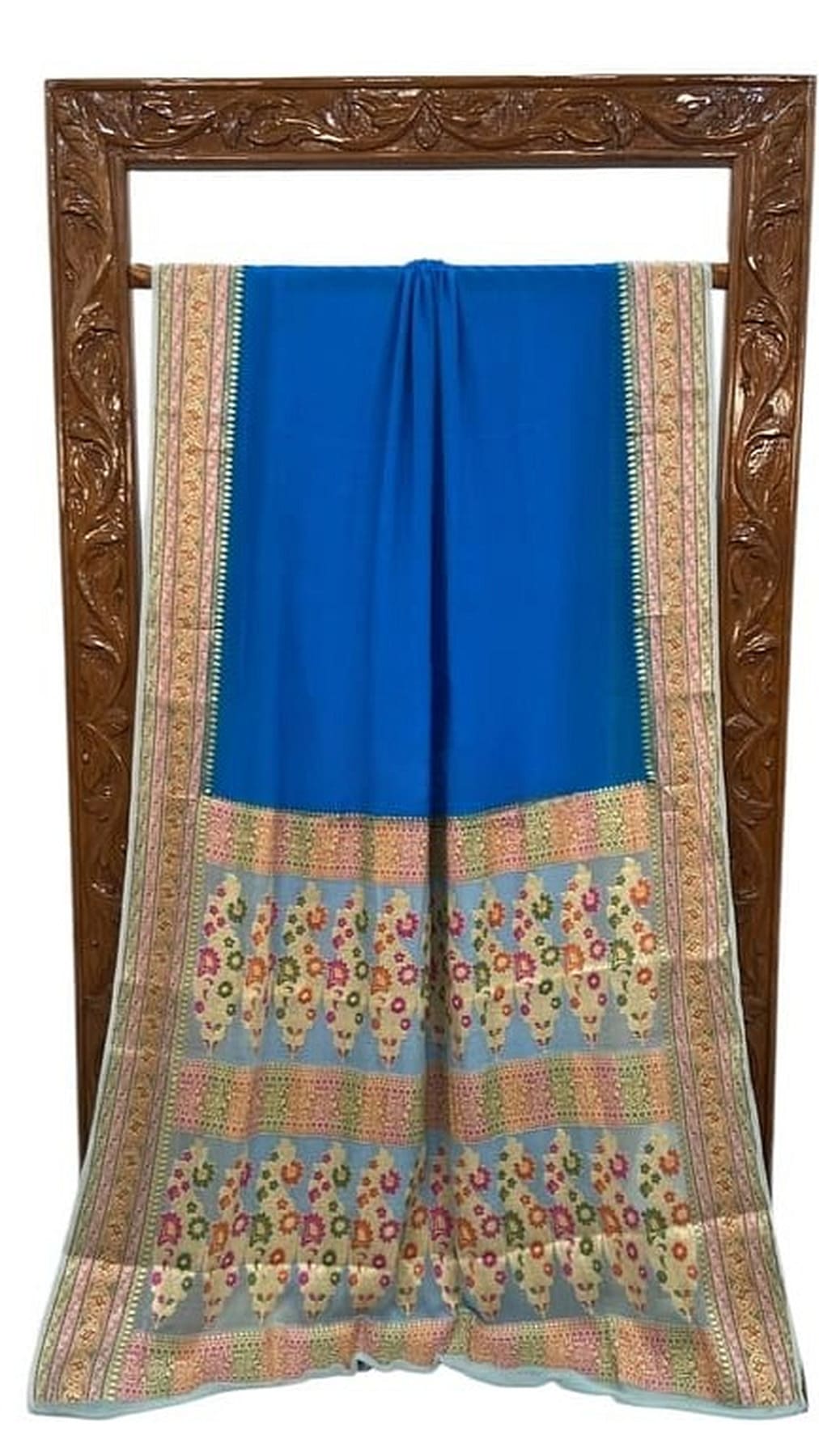 Royal blue saree laid flat, wide multicolor border with decorative motifs and gold trim