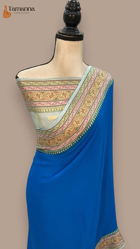 Royal blue saree draped on mannequin, gold-trimmed patterned pallu with striped border