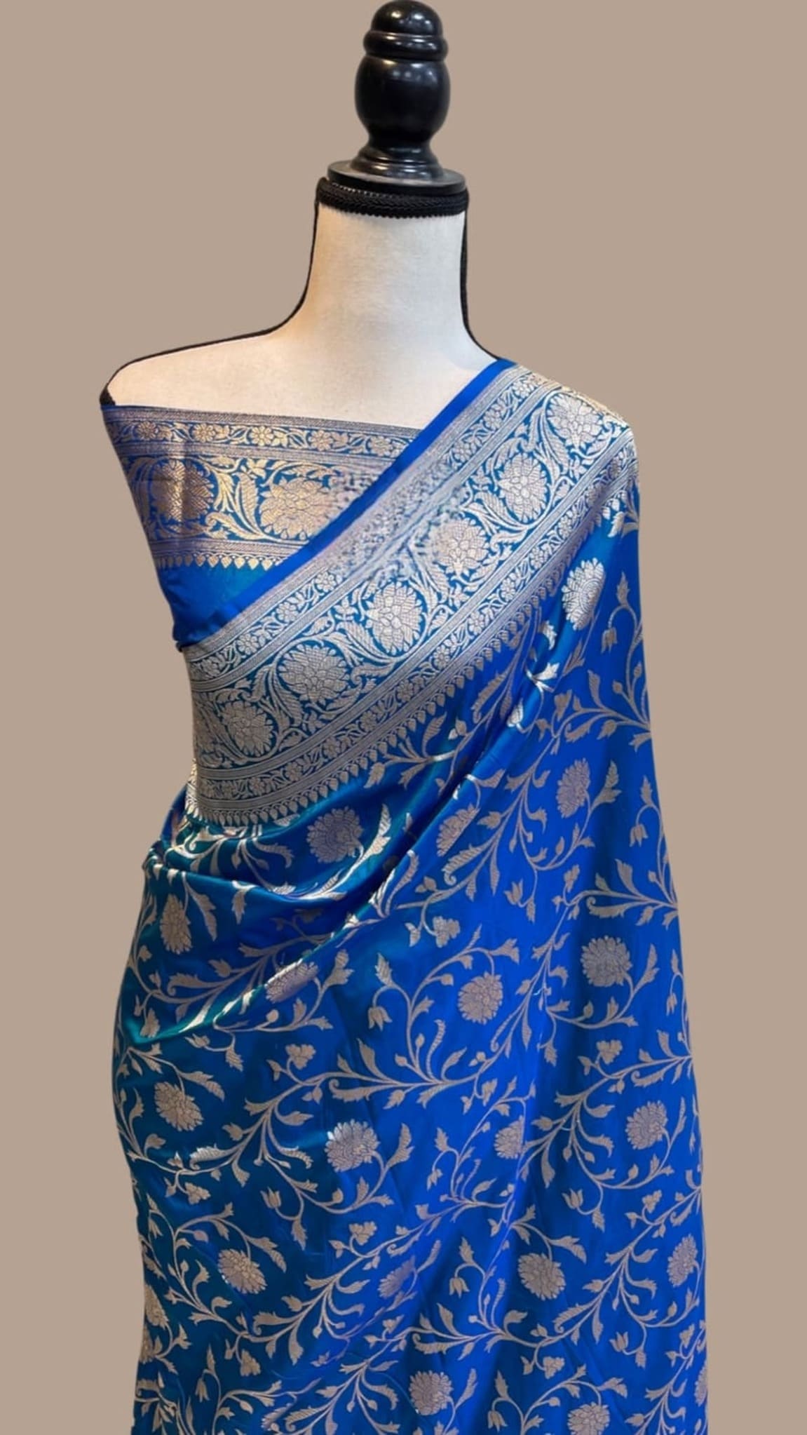 Royal blue silk saree draped on model with light blue pallu border and leaf motifs