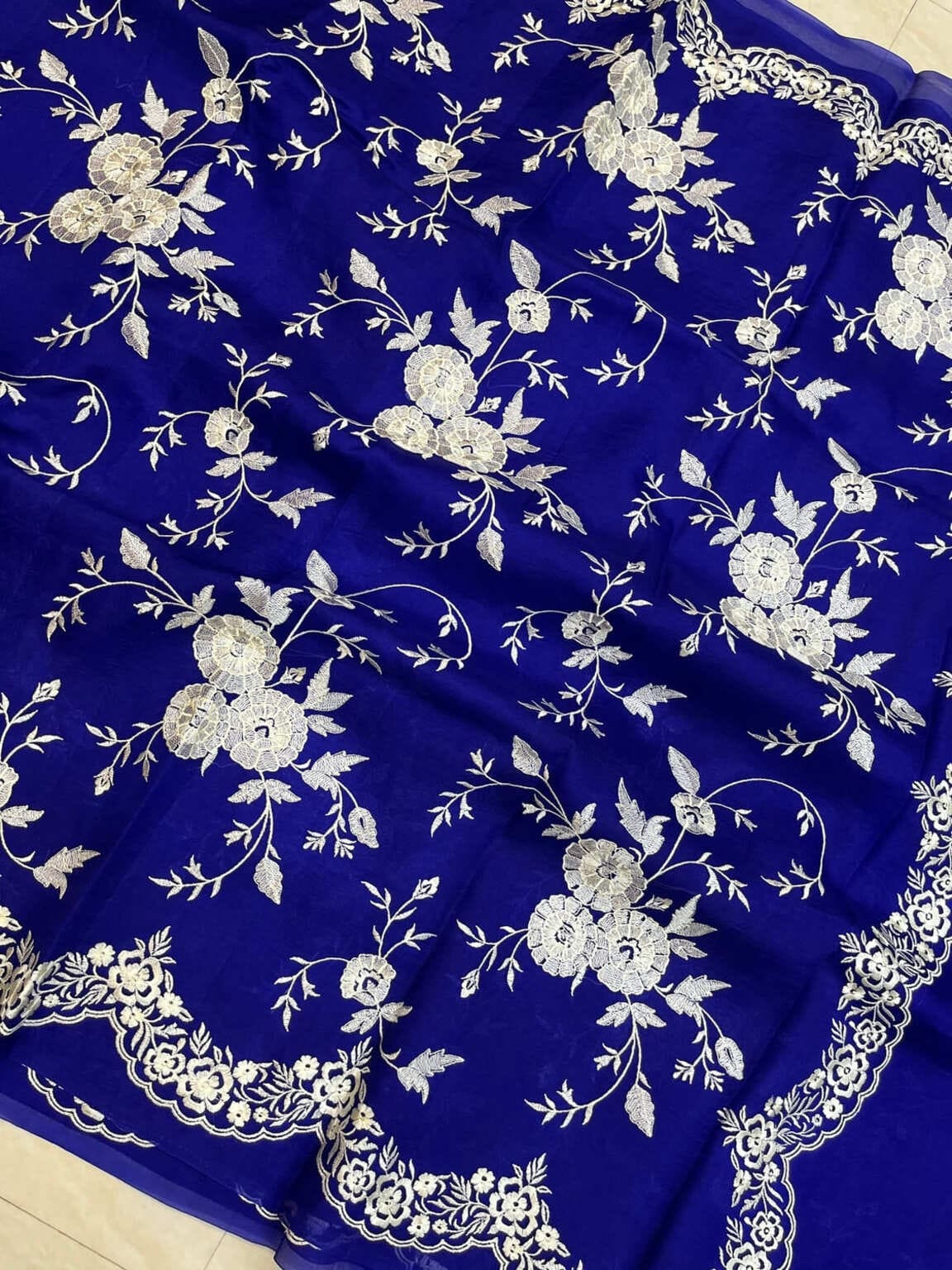 Royal blue organza saree close-up of floral motifs with embroidered edge border