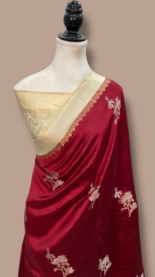 Maroon silk saree on mannequin with cream pallu, gold zari border, floral motifs