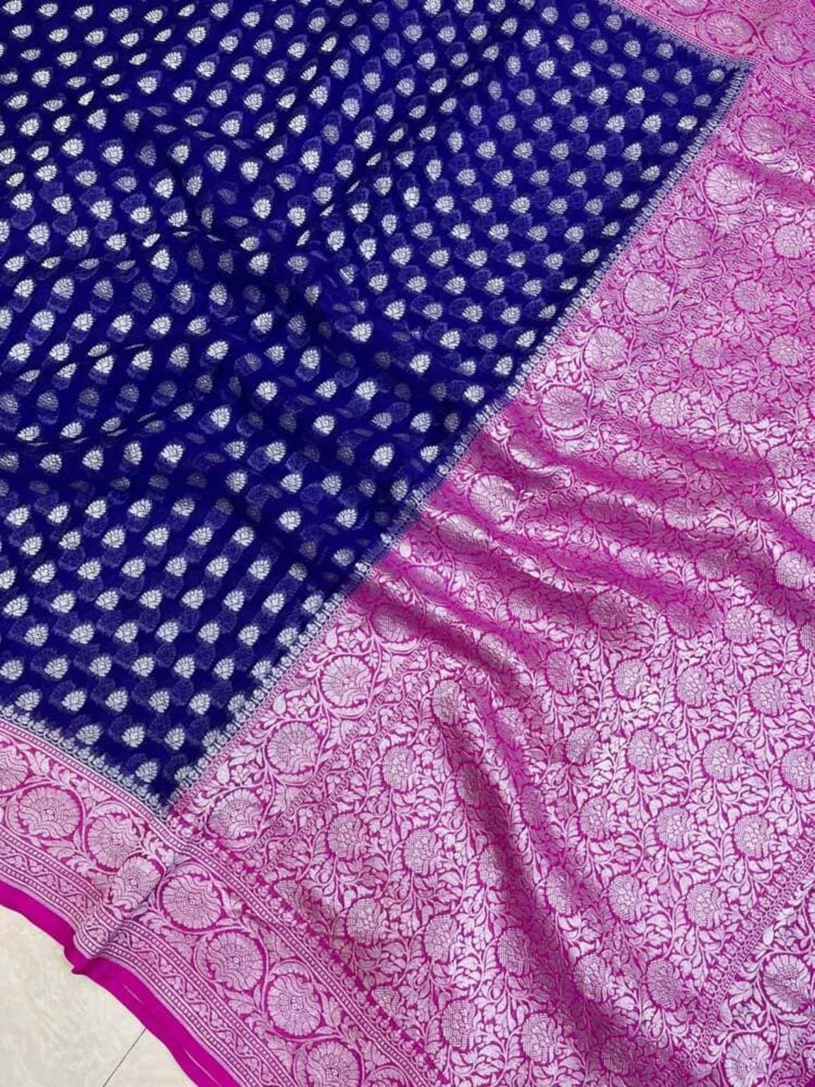 Pink pallu border with floral motifs and royal blue field with tiny white dots