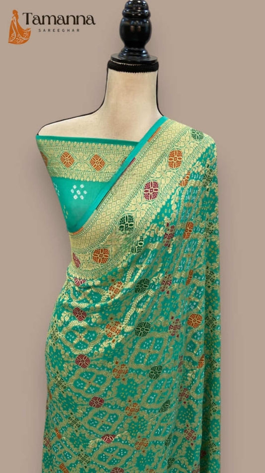 Sea green saree with gold-trim border and multicolor woven motifs on mannequin
