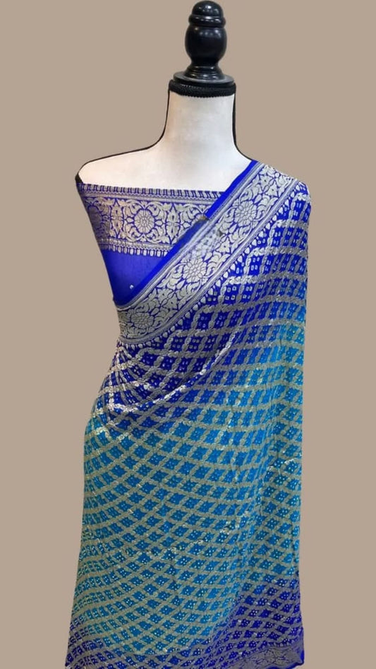 Blue saree on mannequin with checked bandhej body and wide golden patterned pallu border