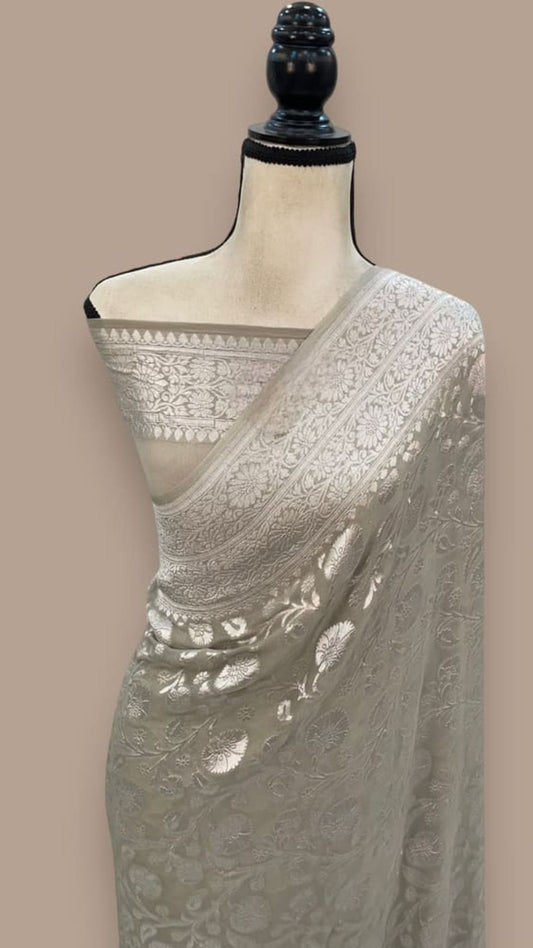 Silver grey Banarasi georgette saree with white floral border and pleated drape
