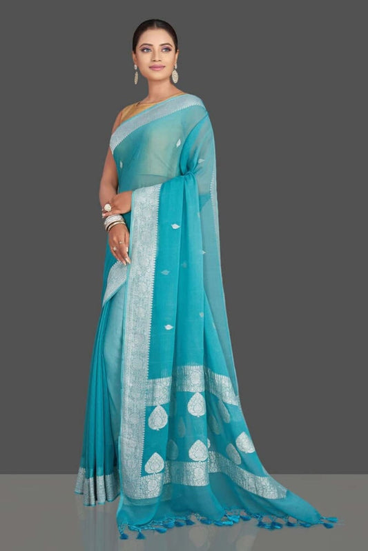 Sky blue georgette Banarasi saree with silver border, patterned pallu, and tassels