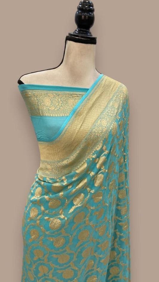 Sky blue saree with gold zari pallu and ornate woven motifs, draped over mannequin
