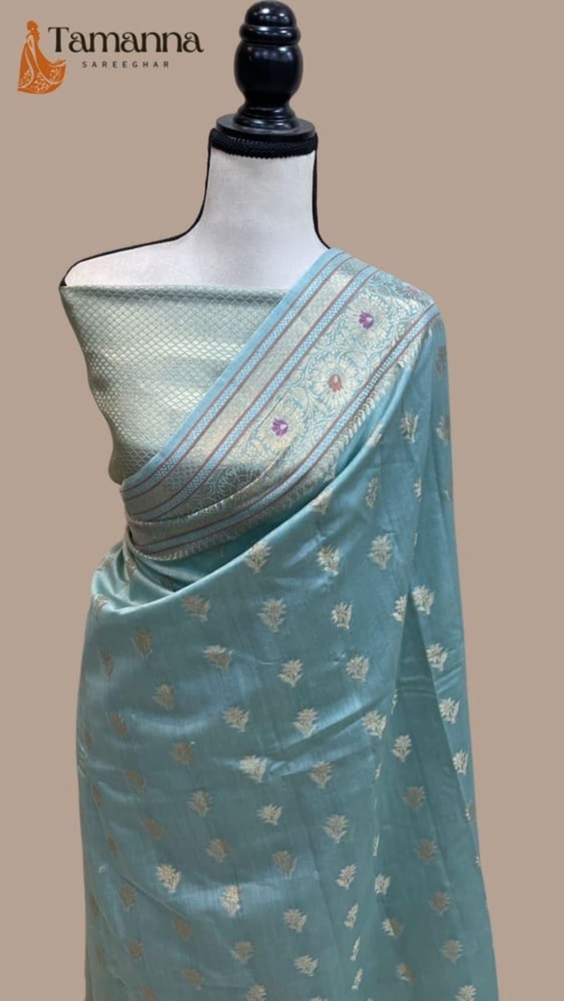 Sky blue cotton saree with gold motifs and diagonal pallu border, shown on mannequin